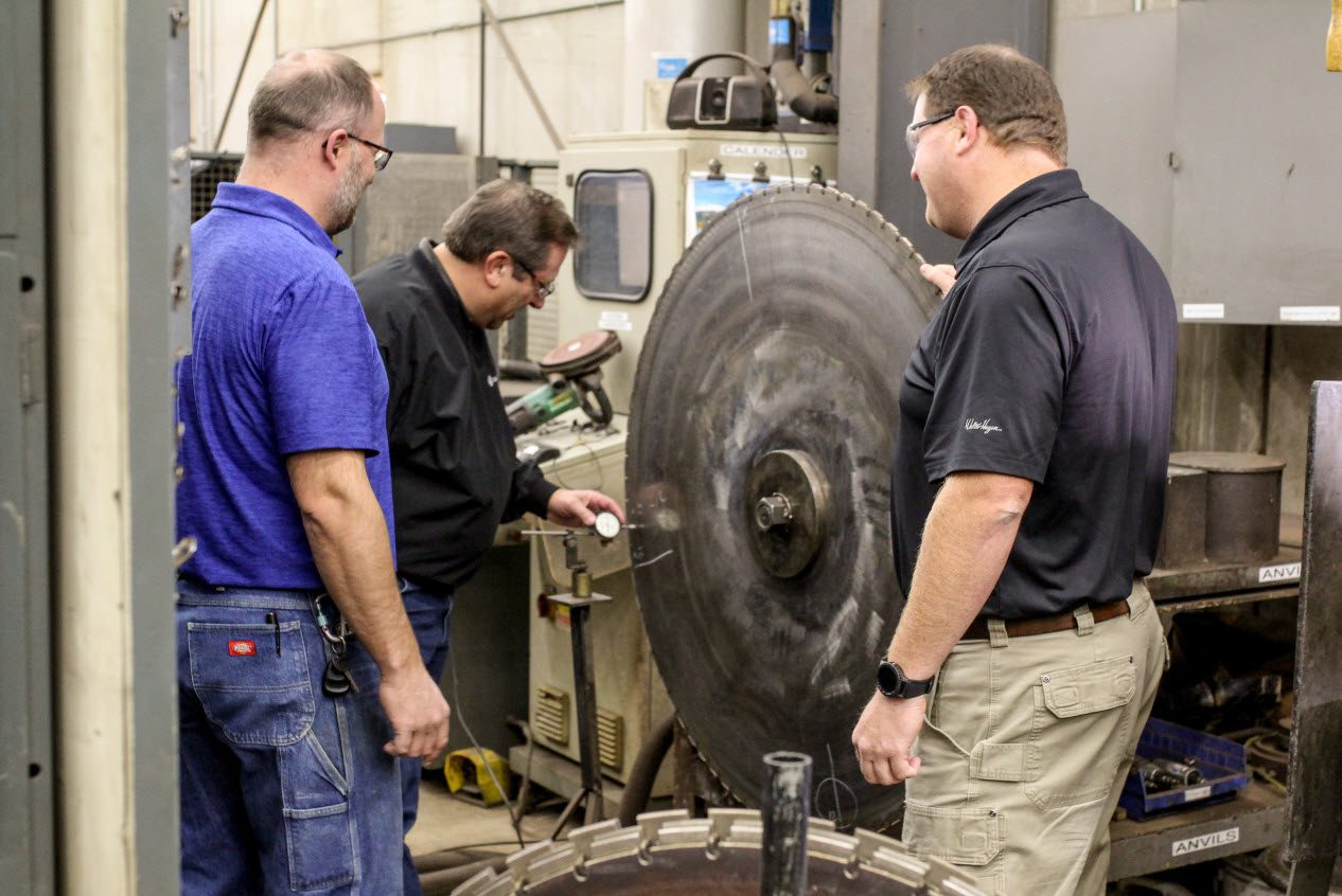 employees around large cutting blade